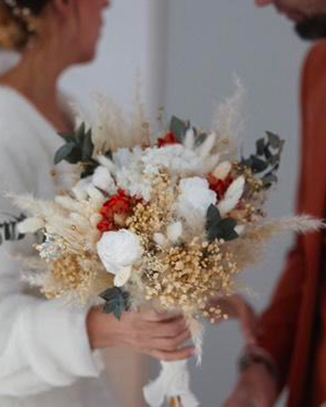 Bouquet de mariée en fleurs tenue en main par une femme couleur orange et blanc