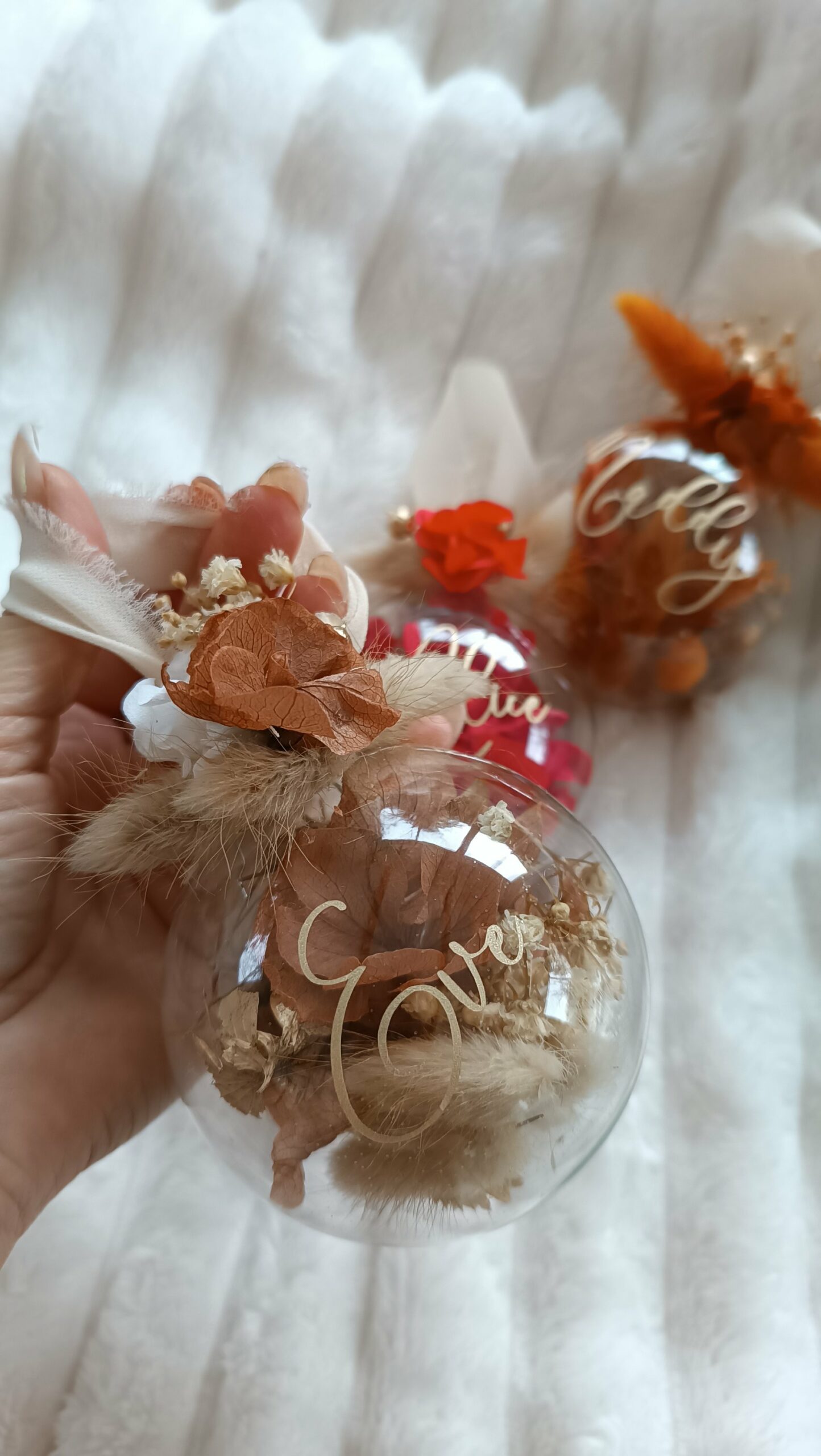 Boule de Noël en verre personnalisée avec prénom, remplie de fleurs séchées naturelles et décorée sur le dessus, idéale pour embellir le sapin et apporter une touche festive et élégante. Décoration de sapin de Noël originale, boule personnalisée en verre avec prénom gravé, contenant des fleurs séchées colorées, parfaite pour une ambiance chaleureuse et authentique. Boule de Noël artisanale en verre, personnalisable avec prénom, garnie de fleurs séchées à l’intérieur, un ornement raffiné pour sapin de Noël et décoration festive de fin d’année. Boue de noël pour mon 1er noël, joyeux noël , belles fêtes de fin d'année, cadeau à personnaliser, idée cadeau fait main à personnaliser avec prénom ou meesage. Ornement de Noël en verre transparent, boule personnalisée avec prénom et fleurs séchées, une décoration unique et naturelle pour sapin de Noël traditionnel ou moderne. Merry Christmas