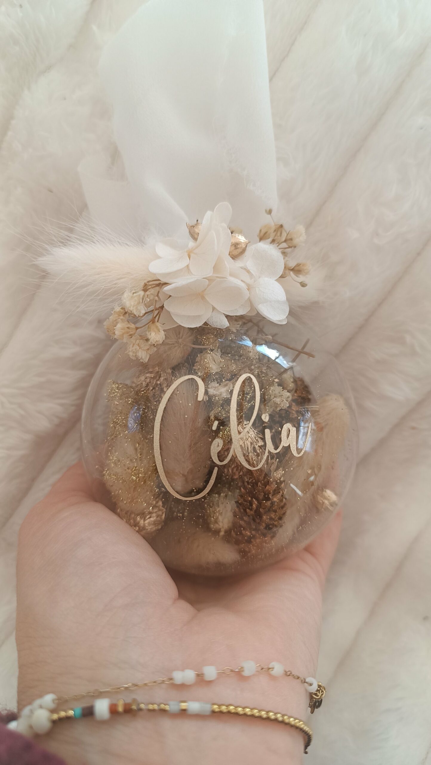 Boule de Noël en verre personnalisée avec prénom, remplie de fleurs séchées naturelles et décorée sur le dessus, idéale pour embellir le sapin et apporter une touche festive et élégante. Décoration de sapin de Noël originale, boule personnalisée en verre avec prénom gravé, contenant des fleurs séchées colorées, parfaite pour une ambiance chaleureuse et authentique. Boule de Noël artisanale en verre, personnalisable avec prénom, garnie de fleurs séchées à l’intérieur, un ornement raffiné pour sapin de Noël et décoration festive de fin d’année. Boue de noël pour mon 1er noël, joyeux noël , belles fêtes de fin d'année, cadeau à personnaliser, idée cadeau fait main à personnaliser avec prénom ou meesage. Ornement de Noël en verre transparent, boule personnalisée avec prénom et fleurs séchées, une décoration unique et naturelle pour sapin de Noël traditionnel ou moderne. Merry Christmas