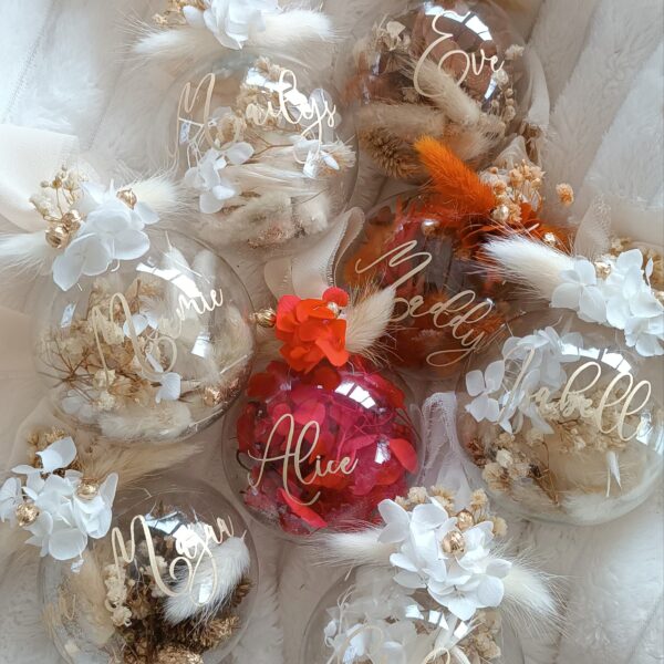 boule de noel en fleurs séchées. Boule de Noël en verre personnalisée avec prénom, remplie de fleurs séchées naturelles et décorée sur le dessus, idéale pour embellir le sapin et apporter une touche festive et élégante. Décoration de sapin de Noël originale, boule personnalisée en verre avec prénom gravé, contenant des fleurs séchées colorées, parfaite pour une ambiance chaleureuse et authentique. Boule de Noël artisanale en verre, personnalisable avec prénom, garnie de fleurs séchées à l’intérieur, un ornement raffiné pour sapin de Noël et décoration festive de fin d’année. Boue de noël pour mon 1er noël, joyeux noël , belles fêtes de fin d'année, cadeau à personnaliser, idée cadeau fait main à personnaliser avec prénom ou meesage. Ornement de Noël en verre transparent, boule personnalisée avec prénom et fleurs séchées, une décoration unique et naturelle pour sapin de Noël traditionnel ou moderne. Merry Christmas