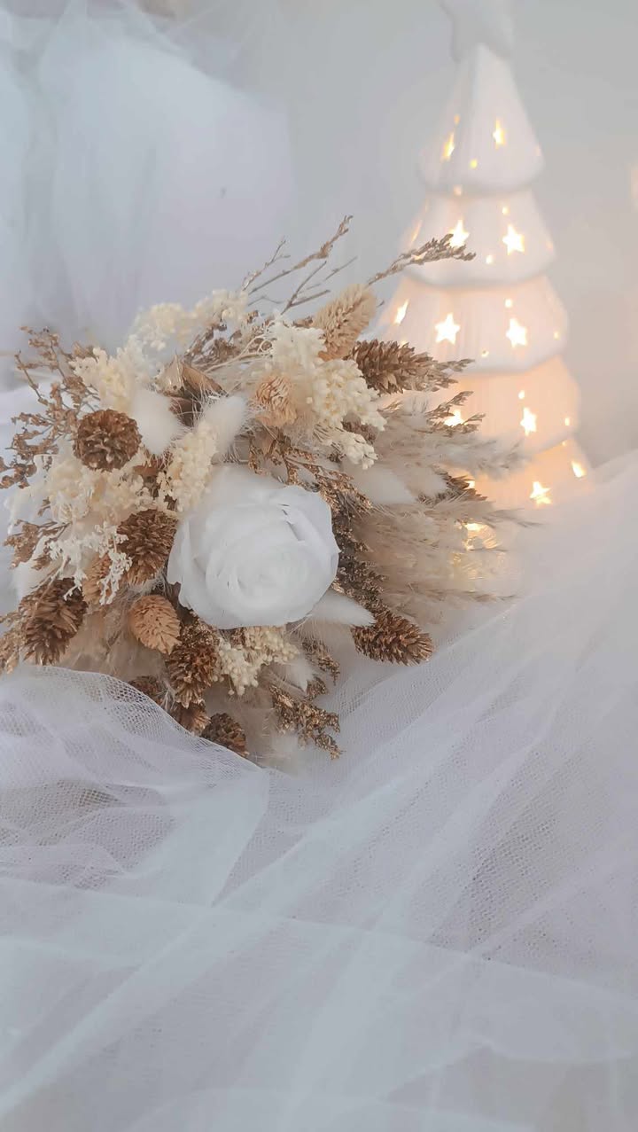 Bouquet de fleurs séchées blanc, beige et doré pour décoration de Noël Centre de table en fleurs séchées naturelles pour les fêtes de fin d’année Bouquet de Noël fait main en fleurs stabilisées et séchées Idée cadeau Noël artisanale : bouquet élégant et durable Décoration de table de fête avec un bouquet en fleurs séchées Bouquet hivernal en fleurs naturelles séchées, tons neutres et dorés Composition florale de Noël blanc et doré pour intérieur chaleureux Bouquet de fleurs séchées pour noël
