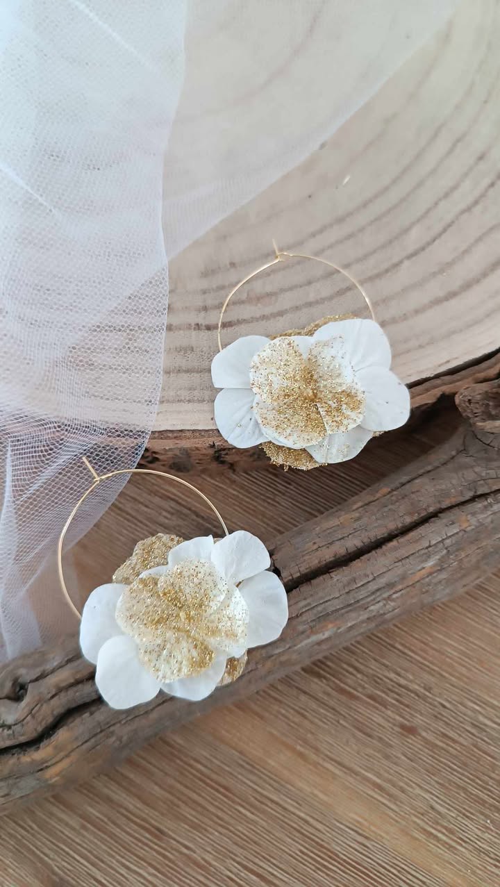 Boucles d’oreilles créoles dorées en acier inoxydable ornées de fleurs séchées blanches et dorées, création artisanale faite main. Boucles d’oreilles créoles dorées en acier inoxydable décorées de fleurs séchées blanches et dorées, bijou fait main au style naturel et élégant. bijoux femme en fleur séchées, cadeau noël femme, idée cadeau bijoux femme bohême et poétique, créoles blanches et doré en fleurs séchées. Boucle d'oreilles à offrir. Boucles d'oreilles créoles pour mariage ou èvenement. Cadeau fête des mamans, idée cadeau fait main fête des grands mères - Boucles d’oreilles créoles dorées en fleurs séchées blanches, création artisanale. Bijoux à offrir naturelle et poétique, création artisanale