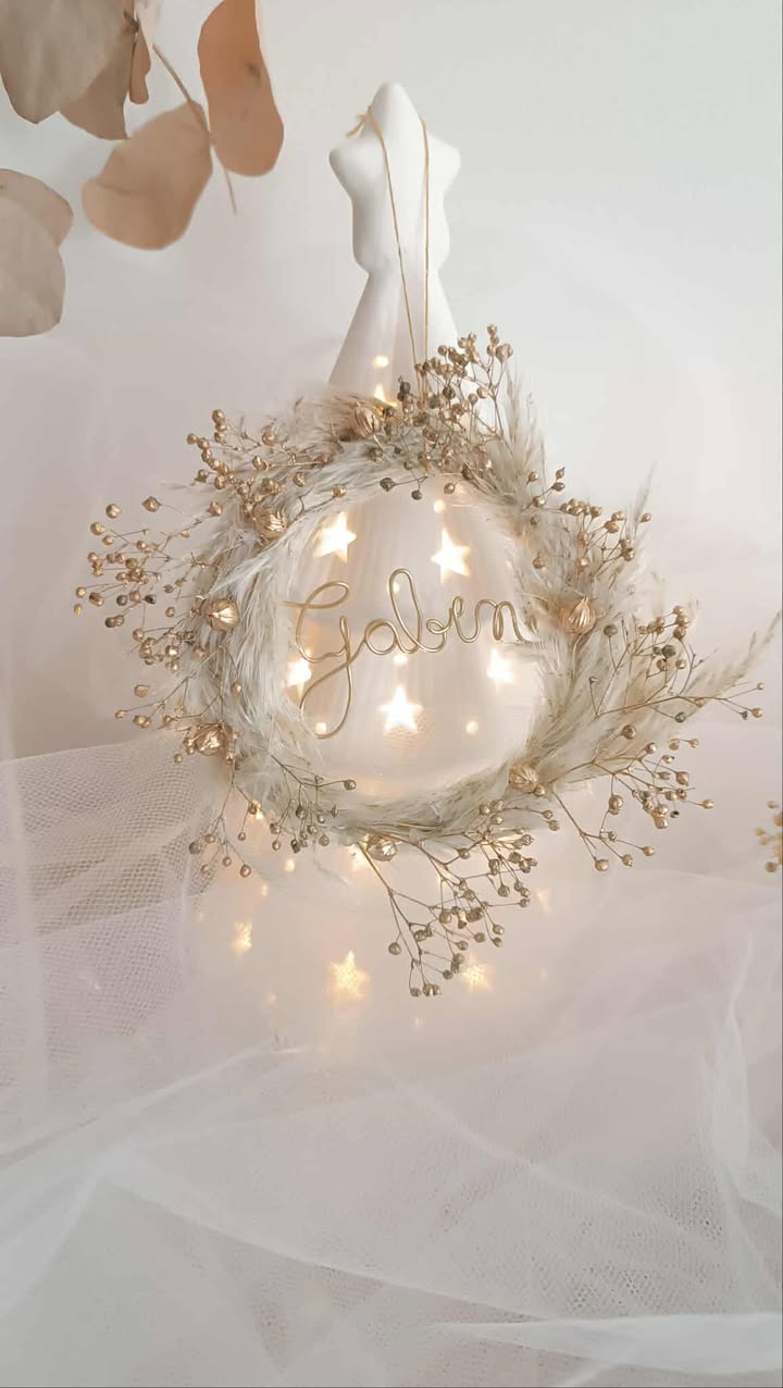 Suspension de Noël artisanale personnalisée en forme de mini couronne, décorée de fleurs séchées de pampas et de boom dorées, avec un prénom en fil doré, faite main, idéale pour décorer le sapin de Noël ou une porte dans un style naturel et poétique. Suspension de noël avec pampa - Ornement sapin de noël chic et bohème à personnaliser - Décoration sapin de noël avec prénom ou mot doux - Idée cadeau à offrir pour noël avec fleurs séchées